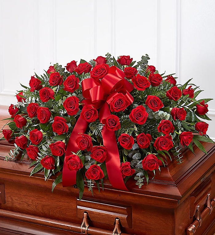Red rose half casket cover arranged as a funeral tribute placed on the casket