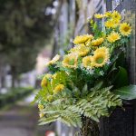 Yellow flowers adorning a tombstone in a serene cemetery