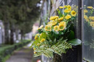 Yellow flowers adorning a tombstone in a serene cemetery