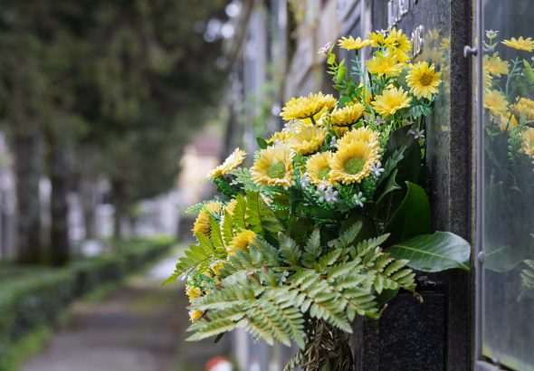 Yellow flowers adorning a tombstone in a serene cemetery